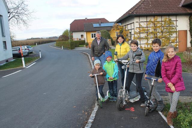 Am neuen Gehsteig Bürgermeister Herbert Froschauer mit Anrainerin Andrea Naderer sowie Simon, Daniel, Silvio, Fabian und Helena. Daneben die verbreiterte Straße.