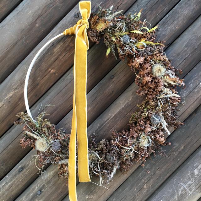 Herbstlicher Hoop mit getrockneten Farnblättern, Fruchtstand des Herbstlöwenzahn, Gräser, Dost und Fruchtstand der Wiesenflockenblume. 