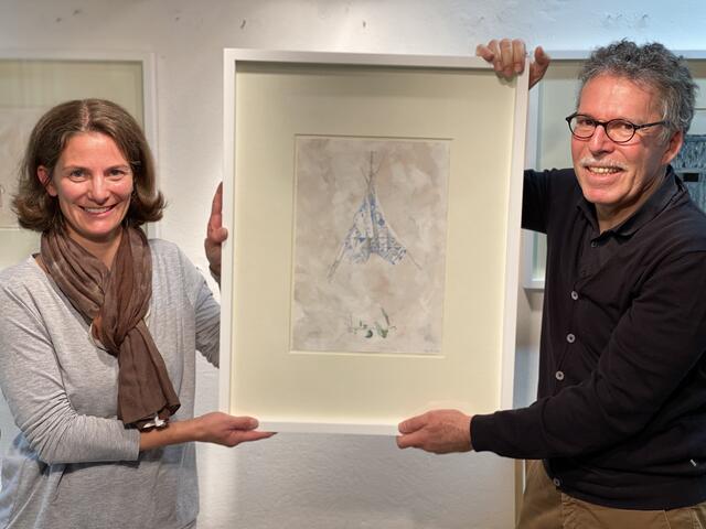 Vorsitzende Karoline Obitzhofer und Künstler Elmar Peintner mit dem Bild „Zelt eines Kindes und entwurzeltes Pflänzchen“, das zugunsten von RETTET DAS KIND TIROL versteigert wird.