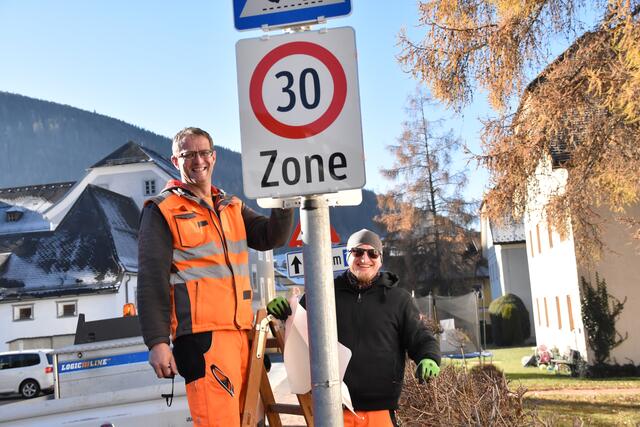 Gemeinde-Bauhofleiter Erwin Seifter (li.) und Mitarbeiter Stefan Makari beim enthüllen einer der neuen Verkehrstafeln.