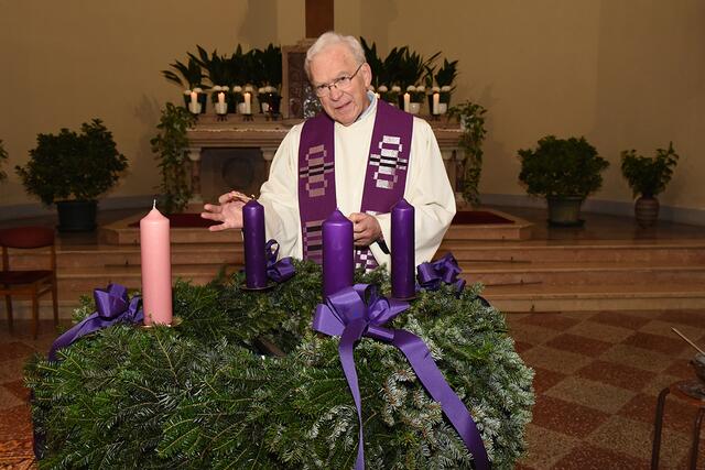 Pater Hans Schwarzl entzündet die erste Kerze am Adventkranz der Pfarre Amstetten Herz Jesu.