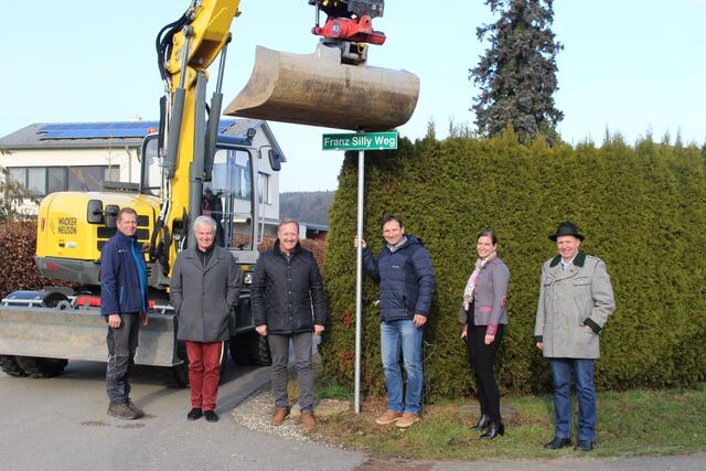 Bürgermeister als Namensgeber: Die Weg-Tafel wurde dieser Tage im Beisein des Vorstandes offiziell mit Bagger und Bauhofmitarbeiter Gerald Pölzl aufgestellt.