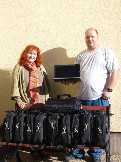Bernhard Bimminger übergibt die Notebooks für die Schüler an Susanne Würleitner.