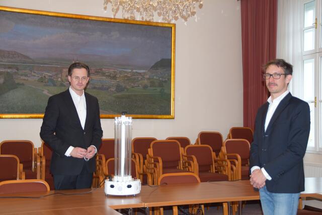 Bürgermeister Stefan Schmuckenschlager und Stephan Hemberger, Geschäftsführer von König & Landl, bei der Inbetriebnahme der mobilen Desinfektionsgeräte. Der große Sitzungssaal kann damit in maximal vier Durchgängen zu je 30 Sekunden komplett virenfrei gemacht werden.