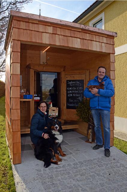 Sabine und Alois Hutterer vor dem Eierautomaten mit Huhn und Hund. Hier werden die Freilandeier ab Hof verkauft.