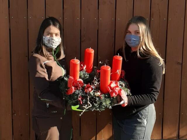Stolz präsentieren Lena und Emily den selbstgemachten Adventkranz.