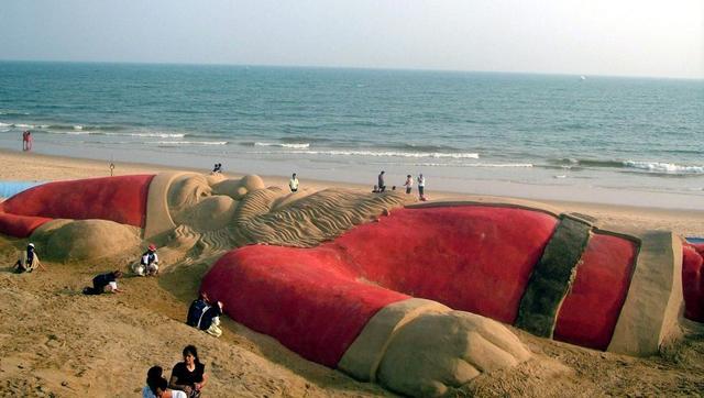 In Ländern auf der Südhalbkugel wird Weihnachten am Strand gefeiert. Da kann der Weihnachtsmann auch schon mal in der Badehose auftauchen – oder wie hier als überdimensionale Sandskulptur.