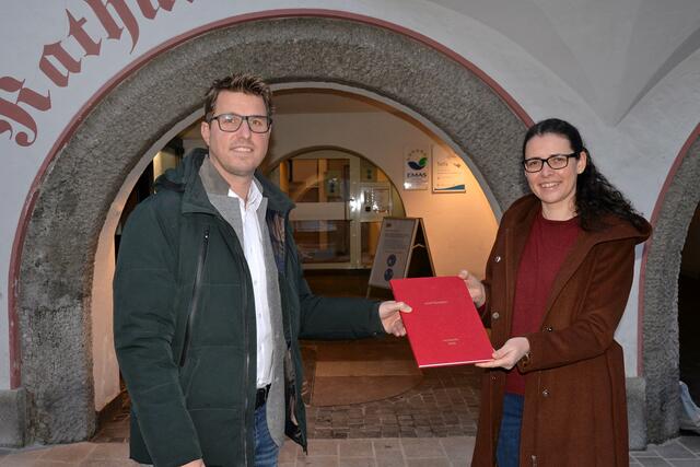 Lena Burgstaller überreicht Bgm. Christian Härting ein Exemplar ihrer Masterarbeit über die Opfer der NS-„Euthanasie“ in Telfs. | Foto: MG Telfs/Dietrich