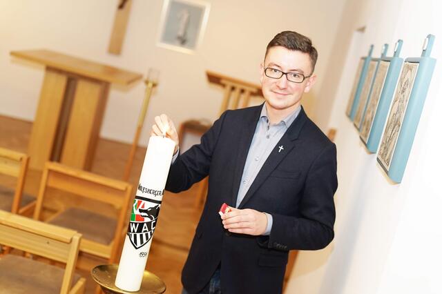 Pfarrer Kranicki mit der WAC-Kerze, die seit dem Spiel gegen Mönchengladbach im Vorjahr bei jedem Europa-League-Spiel des WAC in der Wolfsberger Markuskirche brennt.  | Foto: Zarfl