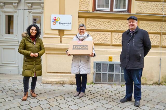 Bezirkschefin Saya Ahmad, Schiuldirektorin Anna Maria Rapp und Einkaufsstraßen-Obmann Eric Rubas freuen sich für die Schulkinder über 35 gespendete Laptops.
