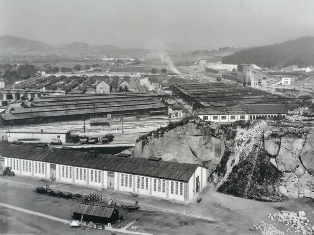 Züge für einen gigantischen Industriekomplex im KZ Gusen: Ganz links ist der Lokschuppen erkennbar, rechts im Hintergrund Gleisanlagen und ein Waggon beim heute noch in Ruinen erhaltenen, riesigen Schotterbrecher. Mittig ganz hinten die weißen Hügel des Bergkristall-Stollenaushubs in St. Georgen. | Foto: US National Archives &amp; Records Administration, Fotorepro Eckhart Herbe.