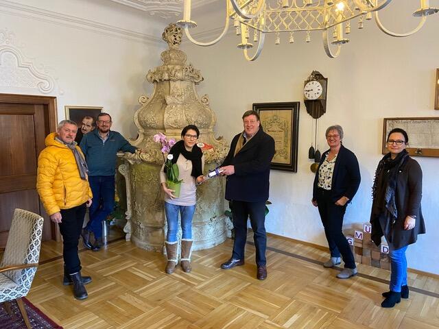Gmünds Bürgermeister Josef Jury überreicht Bettina Posch in Anwesenheit von Gemeindevertretern ein kleines Dankeschön.