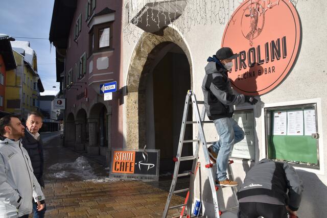 Küchenchef Daniele Passarelli und Wirt Paul Krug begutachten das neue Schild an der Wand neben der Hypo-Bank.