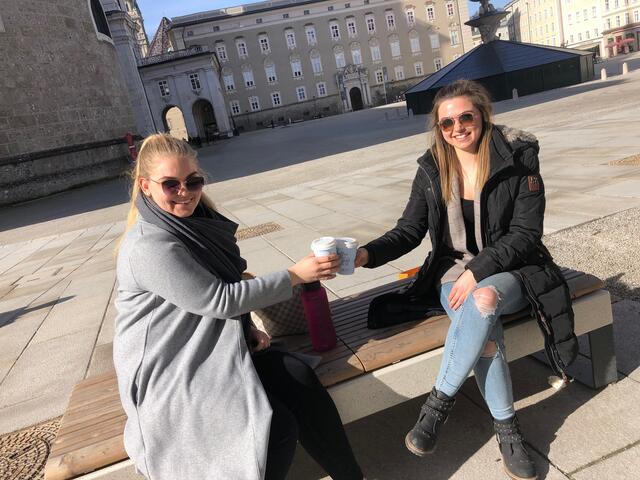 Anna und Adriana genießen ihren ersten "Outdoor-Kaffee" in der Sonne am Residenzplatz