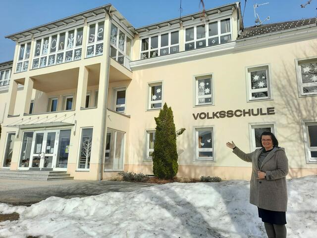 Lendorfs Bürgermeisterin Marika Lagger-Pöllinger zeigt auf das historische Volksschule-Gebäude, dass ab Juni saniert und erneuert wird.