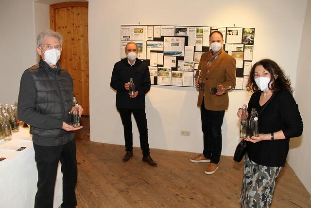 Obmann Karl Schober, Kulturbeauftragter Siegi Galler, Vizebürgermeister Werner Zuschnegg und Kuratorin Helena Wallner (v. l.) mit den dekorativen Wasserflaschen vor der Medienwand | Foto: Josef Fürbass