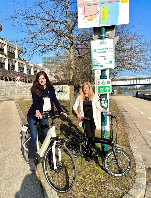 An dieser Stelle soll laut Tourismusstadträtin Doris Lang-Mayerhofer (rechts) und Petra Riffert vom Tourismusverband Donau eine Willkommensstation für Radfahrer entstehen. | Foto: Stadt Linz