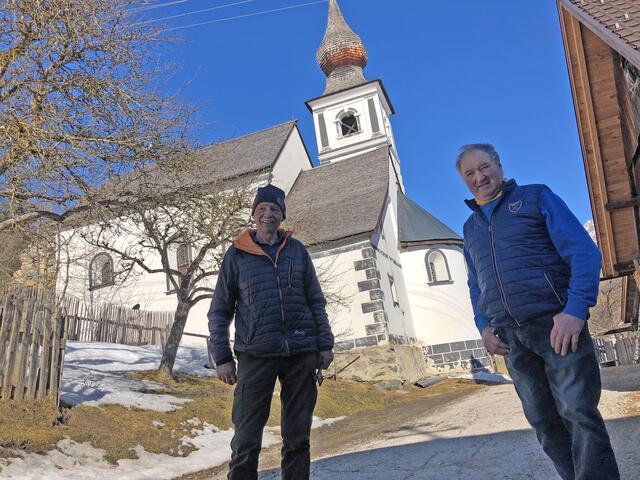 Peter Lerchner (Messner, li.) und Hans Fuchs (ehemaliger Messner) vor der Filialkirche St. Rupert – ein romanischer Sakralbau aus dem 11. beziehungsweise 12. Jahrhundert nach Christus.