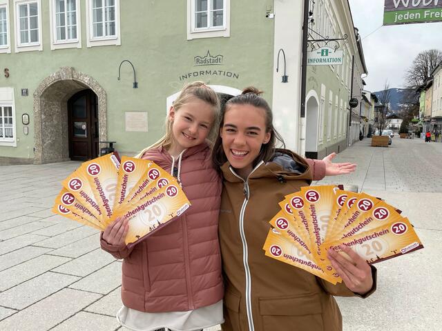 Die Geschwister Sarah und Luisa aus Radstadt freuen sich auf den Einkauf mit den Gutscheinen vom Stadtmarketing Radstadt: Den ersten 20-Euro-Gutschein gibt es in der Karwoche um 20 Prozent verbilligt, das soll die Kaufkraft im Ort stärken.  | Foto: Stadtmarketing Radstadt