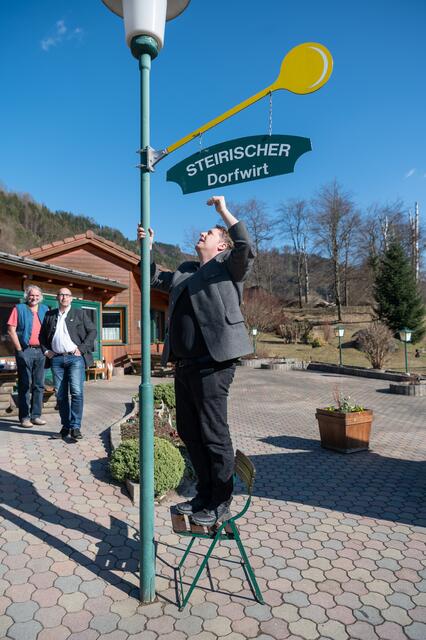 Der Wirt im "Außendienst"! Andreas Tatzl richtet das Dorfwirte-Logo.