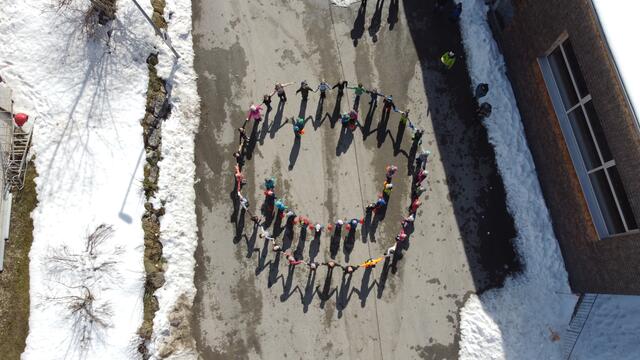 Die Nesselwängler Kinder stellten sich in der Postition eines Smileys auf um zu sagen: Schenk ein Lächeln. | Foto: VS/KIGA Nesselwängle