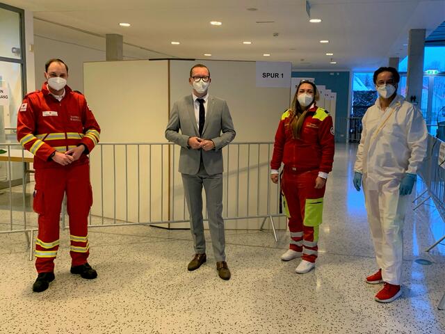 Bürgermeister Georg Djundja mit Mitarbeiterinnen und Mitarbeiter des Roten Kreuz und des Samariterbund Salzburg in der Corona-Teststation im Foyer der Stadthalle Oberndorf.