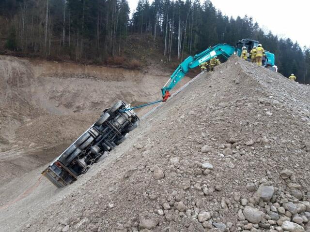 Der abgerutschte Lkw musste mit dem Bagger gesichert werden, ehe der Fahrer befreit werden konnte. | Foto: Feuerwehr Strobl