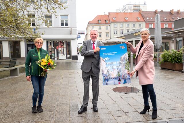 Bürgermeister Klaus Schneeberger präsentiert gemeinsam mit Unternehmervereins-Obfrau Judith Hönig und Michaela Postl (Postl Blumen am Marienmarkt) die Plakat-Kampagne anlässlich der Öffnungen ab 3. Mai.