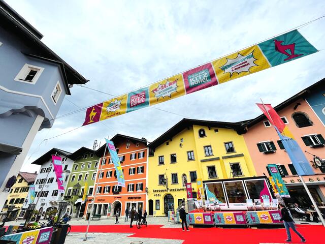 Pop-Up-Radio (u. re.) und langer roter Teppich in der farbenfrohen Kitzbüheler Vorderstadt.