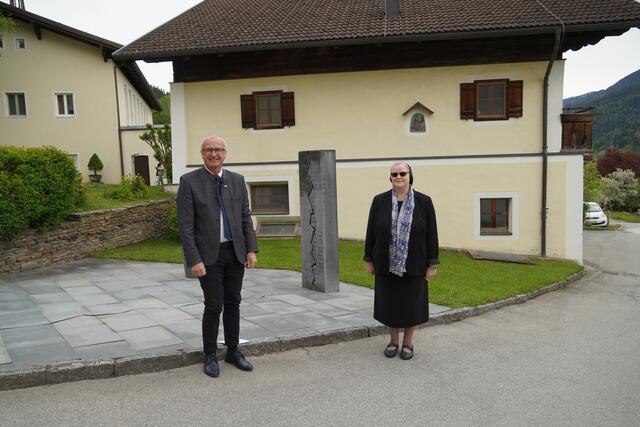 Johannes Dines, Direktor der Caritas Salzburg mit Schwester Angelika Garstenauer, Generaloberin der Franziskanerinnen von Vöcklabruck, vor dem Mahnmal in St. Anton, das an die NS-Zeit erinnert.