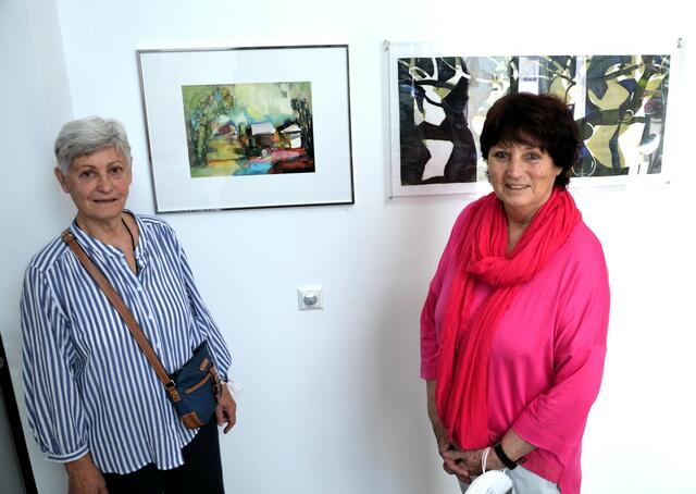 Luzie Pinkas neben ihrem Bali-Aquarell und Erika Drumel vor ihrem Holzschnitt "Baum im Winter"