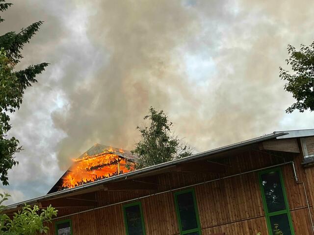 Das Übergreifen der Flammen auf Nebengebäude versuchen die Feuerwehrleute zu verhindern.