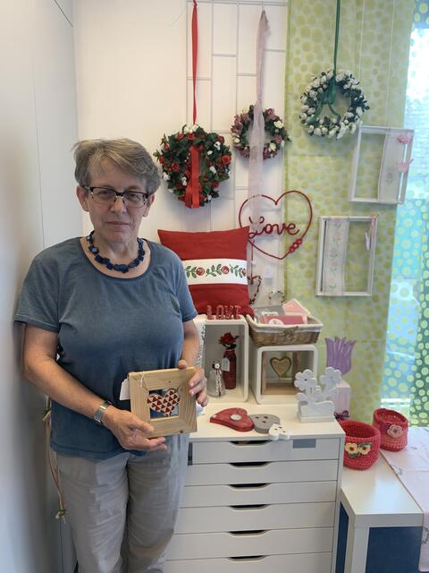 Die Leiterin der Förderwerkstätte Karin Reisner präsentiert stolz die Kunstwerke zum Thema Liebe.