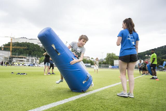 Ein Schüler probiert sich am Stand der Salzburg Ducks an American Football.  | Foto: SPORTUNION/Marc Schwarz