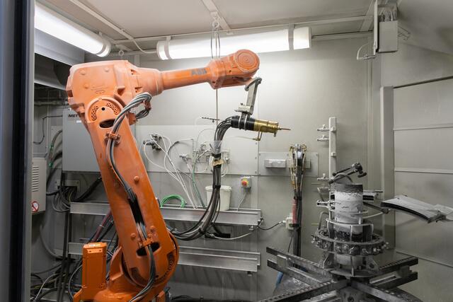 Mithilfe eines Roboterarms werden Wärmedämmschichten auf Testobjekte gespritzt. | Foto: Treibacher Industrie AG