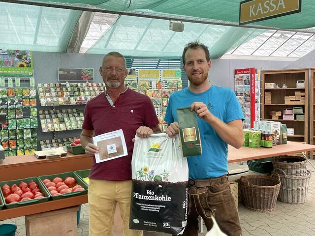 Johannes Macek freut sich über seinen Gewinn. Naturgärtner Simon Wedenig überreicht dem Hobbygärtner ein Dünger-Paket.