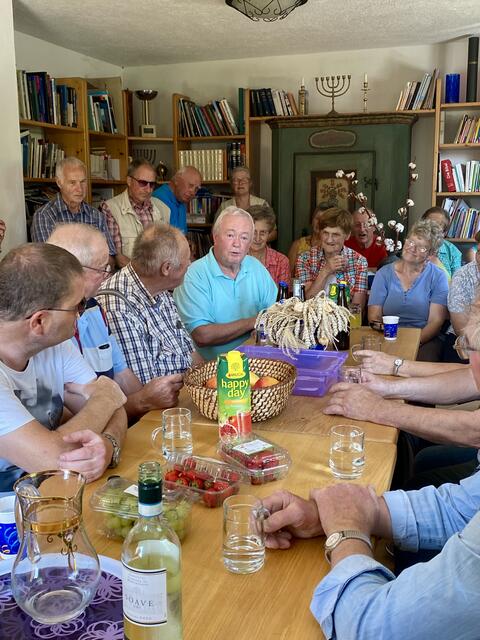 Pfarrer Peter bewirtet seine Gäste in seinem Blockhaus