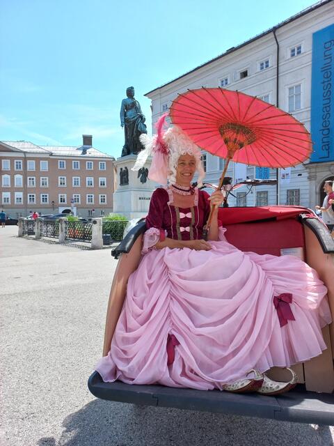 Die Leiterin der Bibliothek der Pfarre Aigen, Beatrix Rigger lädt auf einen Stadtspaziergang durch die Salzburger Altstadt ein. Als "Nannerl" steht sie für Selfies zur Verfügung.