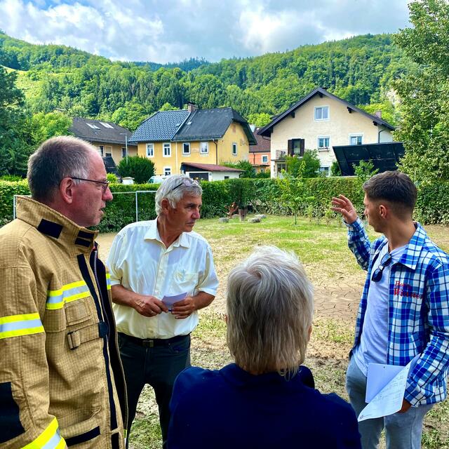 Bürgermeister Alexander Stangassinger (v.l.) und der künftige Schadensermittler Michael Koch beim Besuch der Grießmeisterstraße 9 mit den Betroffenen.