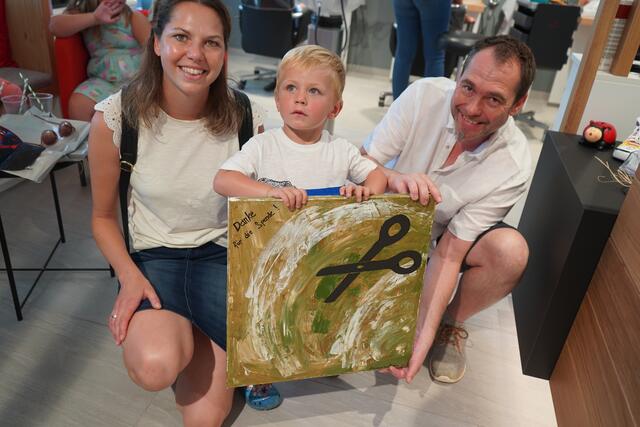 Levin übergibt mit Lisa Sachslehner ein Geschenk der Kindergartenkinder an den Friseurmeister Thomas Schrammel.