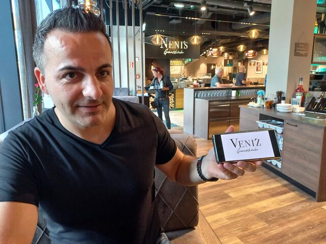 Nedzad "Neni" Djukic präsentiert das neue Logo der "Veni'z Genussküche" in der CYTA Völs.