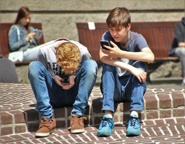 Zwei Jungen die sich mit ihrem Smartphone beschäftigen. Das längere starren auf den Bildschirm fördert die Entstehung von Kurzsichtigkeit.  | Foto: Symbolbild Pexels