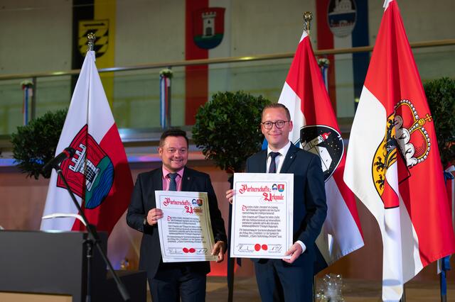 Die beiden Bürgermeister Herbert Pfeffer und Georg Djundja präsentieren stolz die unterzeichnete Partnerschaftsurkunde. | Foto: Stadtgemeinde Oberndorf/Hermeter