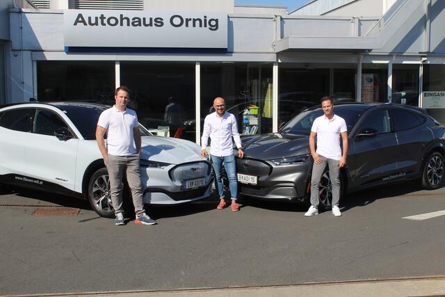 Patrick Wissiak vom Autohaus Ornig bei der Übergabe der beiden Ford Mustang Mach E AWD an Adolf Wrumec (li.) und Manfred Glauninger (re) von Fliesen Adi aus Kaindorf a.d. Sulm.  | Foto: Ornig