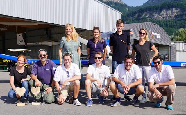 Foto: v.li.n.re.: (stehend) DM-PR-Lady Annette Pac (li) aus Salzburg, überzeugte sich mit Filialleiter/In Sebastian Tiefenthaler, Melanie Lorenz und Kamerafrau Veronika Wieser bei den Rundflugteampiloten (knieend) über die Umsetzung der Kinderflugprojekte.