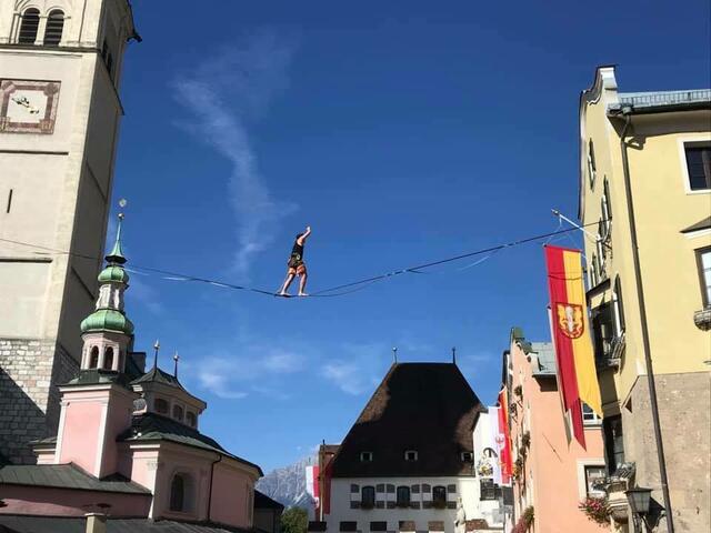 Ein Seiltänzer balanciert in luftigen Höhen über den Oberen Stadtplatz.  | Foto: Stadtmarketing Hall