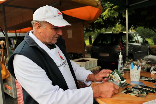 Anhand alter Fotos zeigt Josef Kurzmann, wie der Fernitzer Bauernmarkt vor 30 Jahren ausgesehen hat. | Foto: Edith Ertl