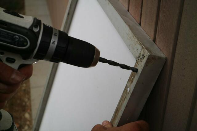 Schwieriger ist die Aufhängung. Wir verwenden den „Solarhook“ eines findigen Freiburger Solareurs und Tüftlers.
Da die 100w Module kleiner sind und jenseits jeder Garantie, bohren wir Löcher in den Rahmen und machen den Haken daran fest. | Foto: SolarBalkon
