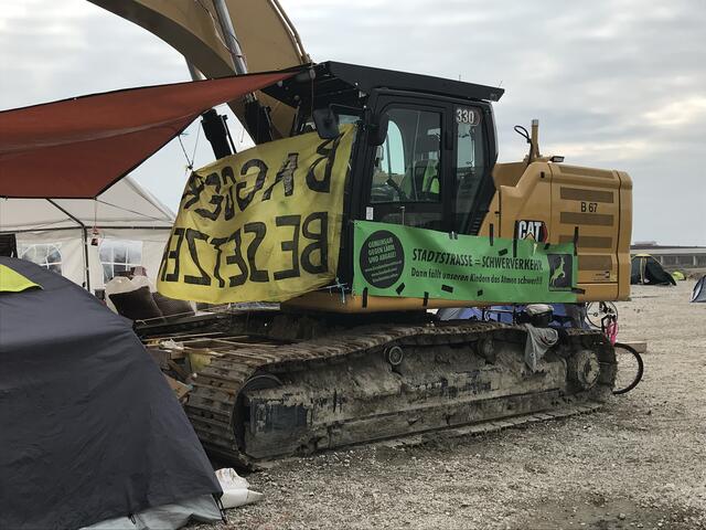 Die Bagger auf der Baustelle wurden mit Transparenten verhüllt.