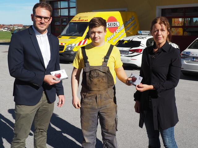 Marco Wuppinger, AMS (Erfinder der Lehrstellen-Challenge), Lukas, 18-jähriger Lehrling bei der Firma Seidl und Christa Schweinberger, stellvertretende Landesgeschäftsführerin AMS, bei der Übergabe der Führerscheingutscheine der Fahrschule Zebra.